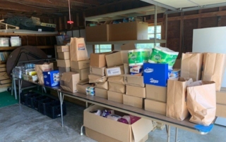 Boxes of food and household essentials are piled on a table at the Edgerton Community Food Pantry on August 12, 2022