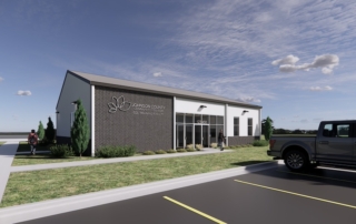 A rendering of the exterior of the new CDL Training Center that Johnson County Community College is building. It's left side is a dark brick with the JCCC logo, doors and glass in the middle. The far right side of the building has two windows.